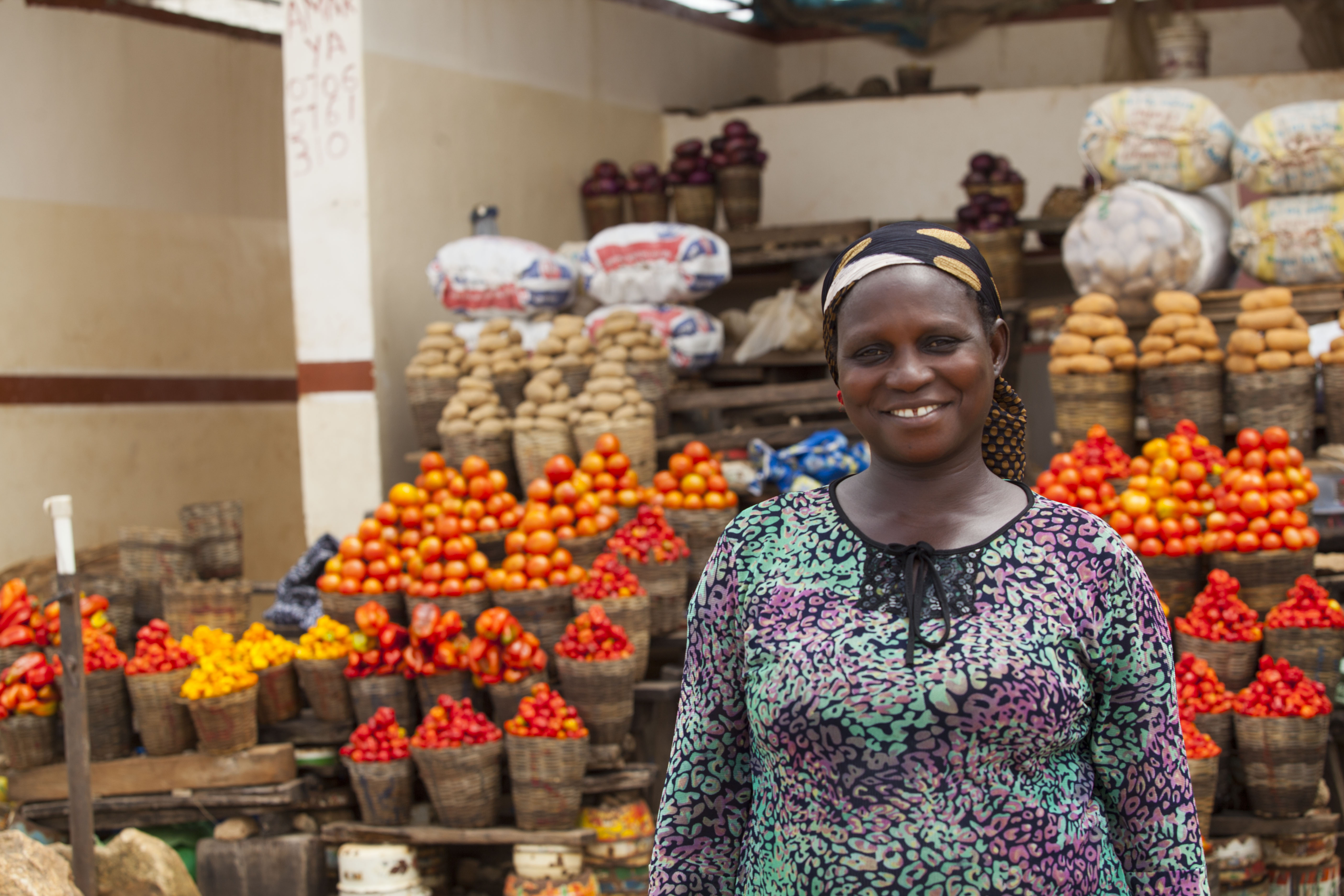 image of african woman purchasing produce, smiling at the camera.